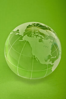 Glass globe on green background, close up - TSF000113