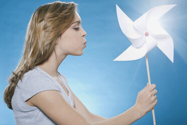 Teenage girl holding paper windmill - WESTF016112