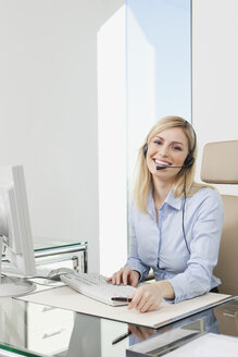 Germany, Frankfurt, Business woman wearing headset and using computer - SKF000438