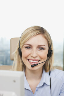 Germany, Frankfurt, Business woman wearing headset, smiling, portrait - SKF000440