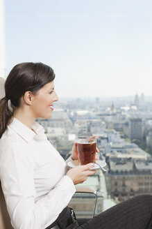 Germany, Frankfurt, Business woman drinking tea, smiling - SKF000463