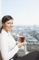 Germany, Frankfurt, Business woman drinking tea, smiling, portrait - SKF000464