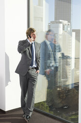 Germany, Frankfurt, Businessman on the phone in office - SKF000465