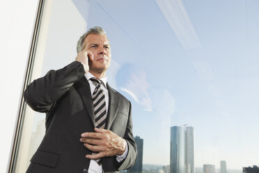 Germany, Frankfurt, Businessman on the phone in office - SKF000489