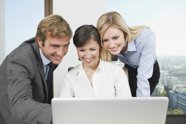 Germany, Frankfurt, Business people using laptop and discussing - SKF000523