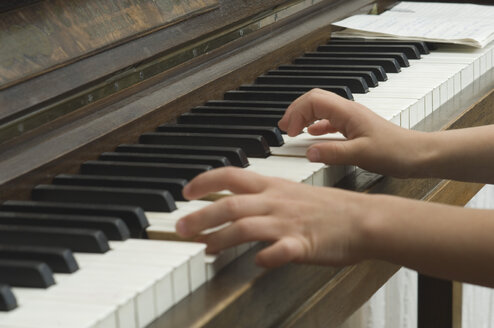 Germany, Bavaria, Girl using piano and making music - CRF002047