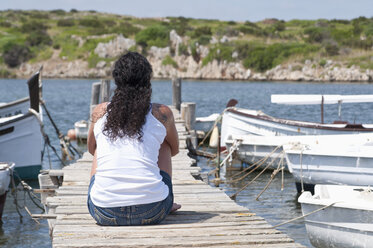 Spanien, Balears, Menorca, Mittlere erwachsene Frau entspannt sich auf Steg - UMF000339