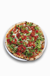 Pizza garnished with tomatoes, ham, rocket salad and parmesan - CSF014635