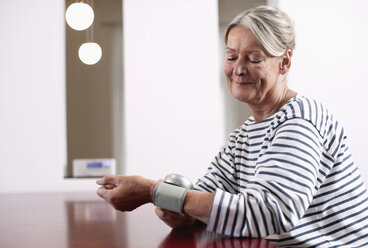 Germany, Wakendorf, Senior woman checking blood pressure - WESTF016188