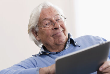 Germany, Wakendorf, Senior man using laptop, smiling - WESTF016213