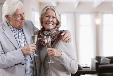 Germany, Wakendorf, Senior couple with sparkling wine, smiling - WESTF016231