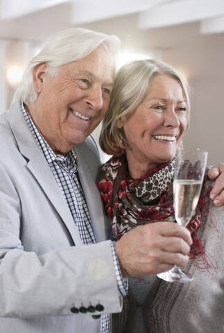 Deutschland, Wakendorf, Seniorenpaar mit Sekt, lächelnd, lizenzfreies Stockfoto