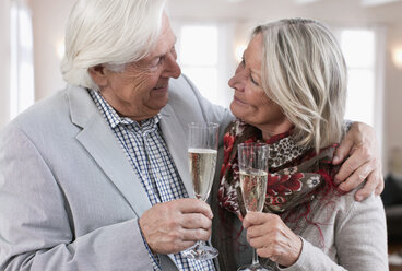 Germany, Wakendorf, Senior couple with sparkling wine, smiling - WESTF016233