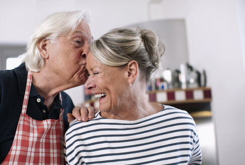 Germany, Wakendorf, Senior man kissing woman forehead - WESTF016249