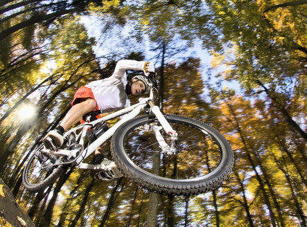 Germany, Bavaria, Landshut, Man riding electric mountain bike in forest - RNF000656