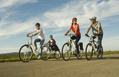 Germany, Bavaria, Raisting, People riding electric bicycle near radio station - RNF000665