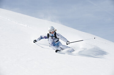 Österreich, Kleinwalsertal, Junge Frau beim Skifahren und lächelnd - MRF001260