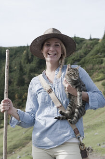 Österreich, Salzburger Land, Filzmoos, Junge Frau mit Katze, lächelnd, Porträt - HHF003460