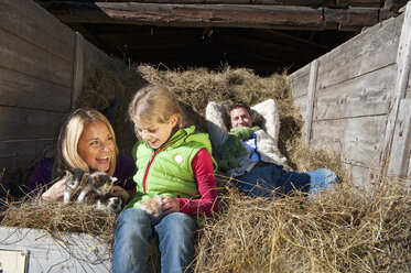 Austria, Salzburg, Flachau, Family lying in hay trailer - HHF003491