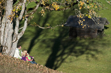 Austria, Salzburg, Flachau, Family sitting in autumn meadow - HHF003501
