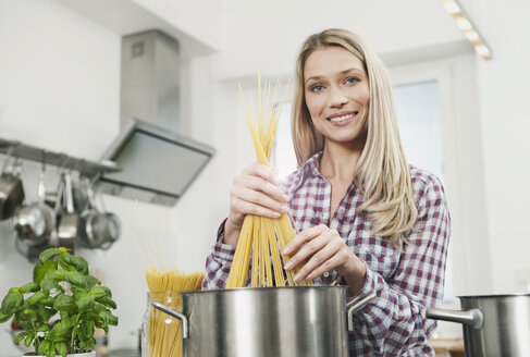 Germany, Cologne, Woman cooking spaghetti, portrait, smiling - WESTF016272
