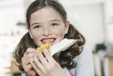 Germany, Cologne, Girl eating a slice of pizza - WESTF016284