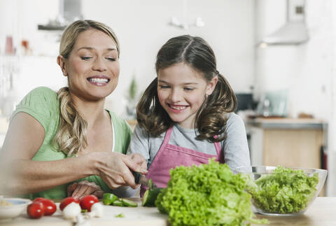 Deutschland, Köln, Mutter und Tochter bereiten Salat zu, lizenzfreies Stockfoto