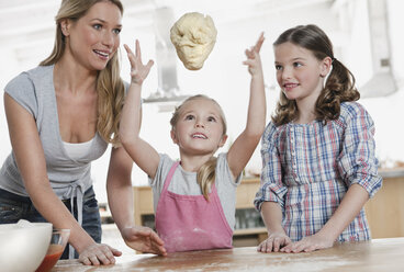 Germany, Cologne, Mother and children preparing dough - WESTF016341