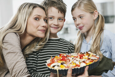 Deutschland, Köln, Mutter und Kinder mit Pizza in der Küche - WESTF016354