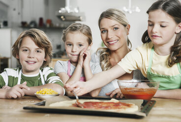 Germany, Cologne, Mother and children in kitchen making pizza - WESTF016372