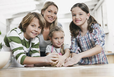 Germany, Cologne, Mother and children in kitchen making pizza - WESTF016373