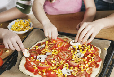 Deutschland, Köln, Mutter und Kinder garnieren Pizza - WESTF016380