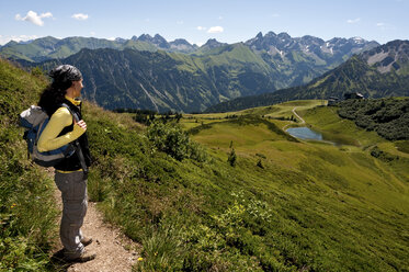 Deutschland, Bayern, Allgäuer Alpen, Frau stehend mit Blick auf Aussicht - UMF000310