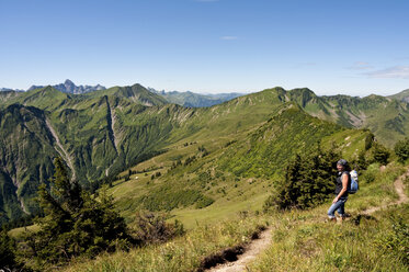 Austria, Vorarlberg, Allgaeu Alps, Woman standing with rucksack - UMF000315