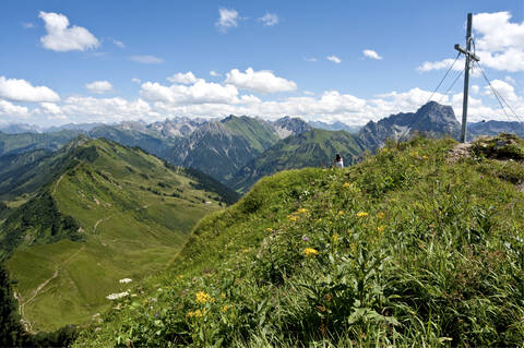 Österreich, Vorarlberg, Frau sitzt auf Berg, lizenzfreies Stockfoto