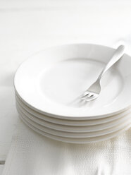 Stack of plates with fork, close-up - KSWF000685
