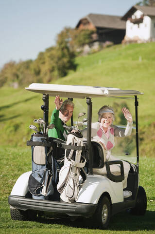 Italien, Kastelruth, Älteres Paar in Golfwagen auf Golfplatz, lächelnd, Porträt, lizenzfreies Stockfoto