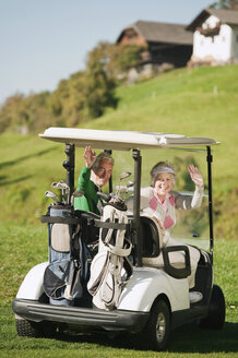 Italy, Kastelruth, Mature couple in golf cart on golf course, smiling, portrait - WESTF016425