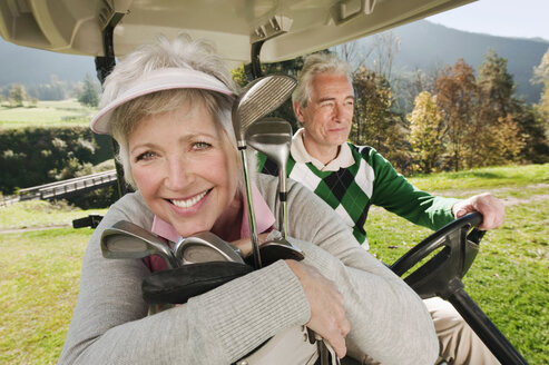 Italy, Kastelruth, Mature couple in golf cart on golf course - WESTF016430