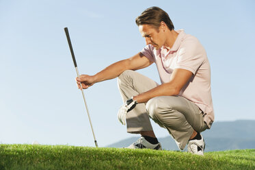 Italien, Kastelruth, Mittlerer Erwachsener Mann mit Golfschläger auf Golfplatz - WESTF016458
