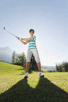 Italien, Kastelruth, Mittlere erwachsene Frau mit Golfschläger auf Golfplatz - WESTF016468