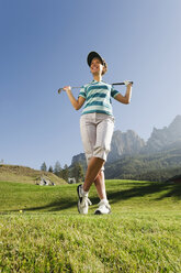 Italien, Kastelruth, Mittlere erwachsene Frau mit Golfschläger auf Golfplatz - WESTF016469