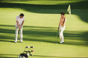 Italy, Kastelruth, Golfers playing golf on golf course - WESTF016515