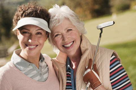 Italy, Kastelruth, Golfers on golf course, smiling, portrait stock photo