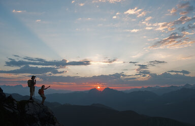 Österreich, Salzburger Land, Altenmarkt-Zauchensee, Pärchen beobachtet Sonnenaufgang in den Niederen Tauern - HHF003583