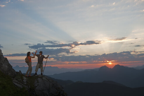 Österreich, Salzburger Land, Altenmarkt-Zauchensee, Pärchen gibt High Five auf den Bergen der Niederen Tauern - HHF003585