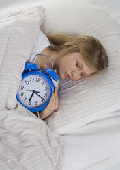 Mädchen schlafend auf Bett mit Wecker - WWF001869