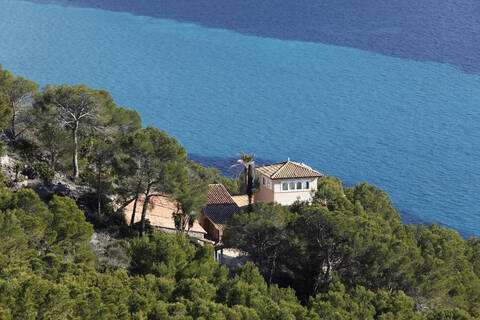 Spanien, Balearische Inseln, Mallorca, Blick auf ein Gebäude zwischen Bäumen, lizenzfreies Stockfoto