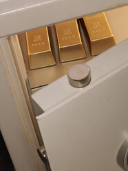 Three pieces of gold bullion in locker, close up - AKF000237