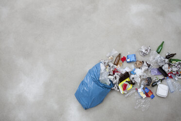 Garbage spilling from plastic bag on gray background - BAEF000179